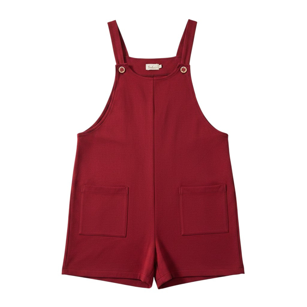 Macacão curto Tralulu vermelho com alças ajustáveis, botões decorativos e dois bolsos frontais.