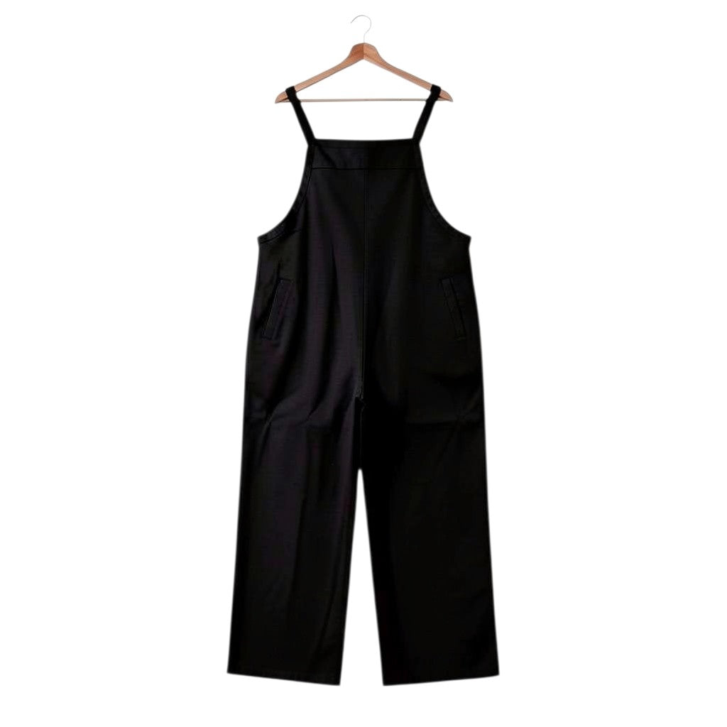 Macacão jardineira Tralulu preto de corte largo com alças ajustáveis e bolsos laterais, estilo casual e moderno.